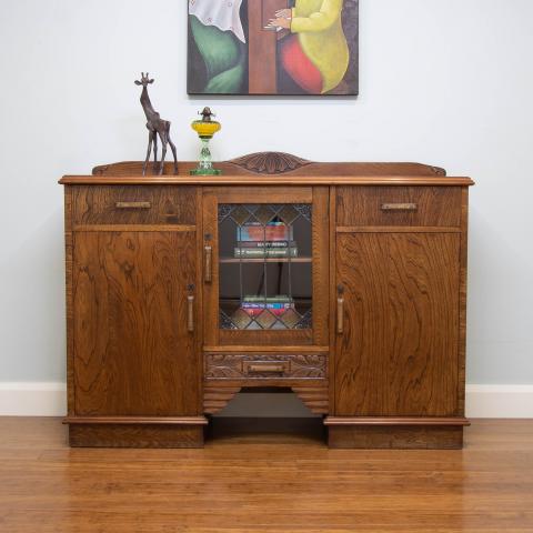 This 1930's oak sideboard is a lovely example of using a mix of carved solid oak timber and magnificent oak timber veneer.
