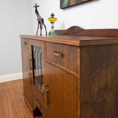 This 1930's oak sideboard is a lovely example of using a mix of carved solid oak timber and magnificent oak timber veneer.